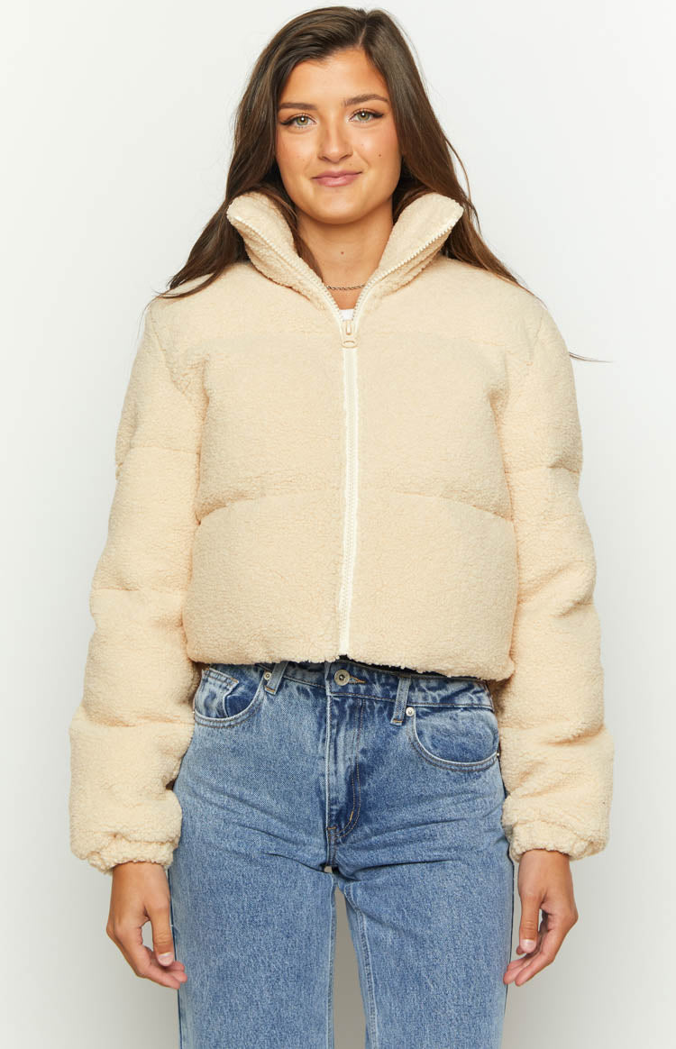 Front view of a cream teddy puffer jacket with a high collar and white front zipper