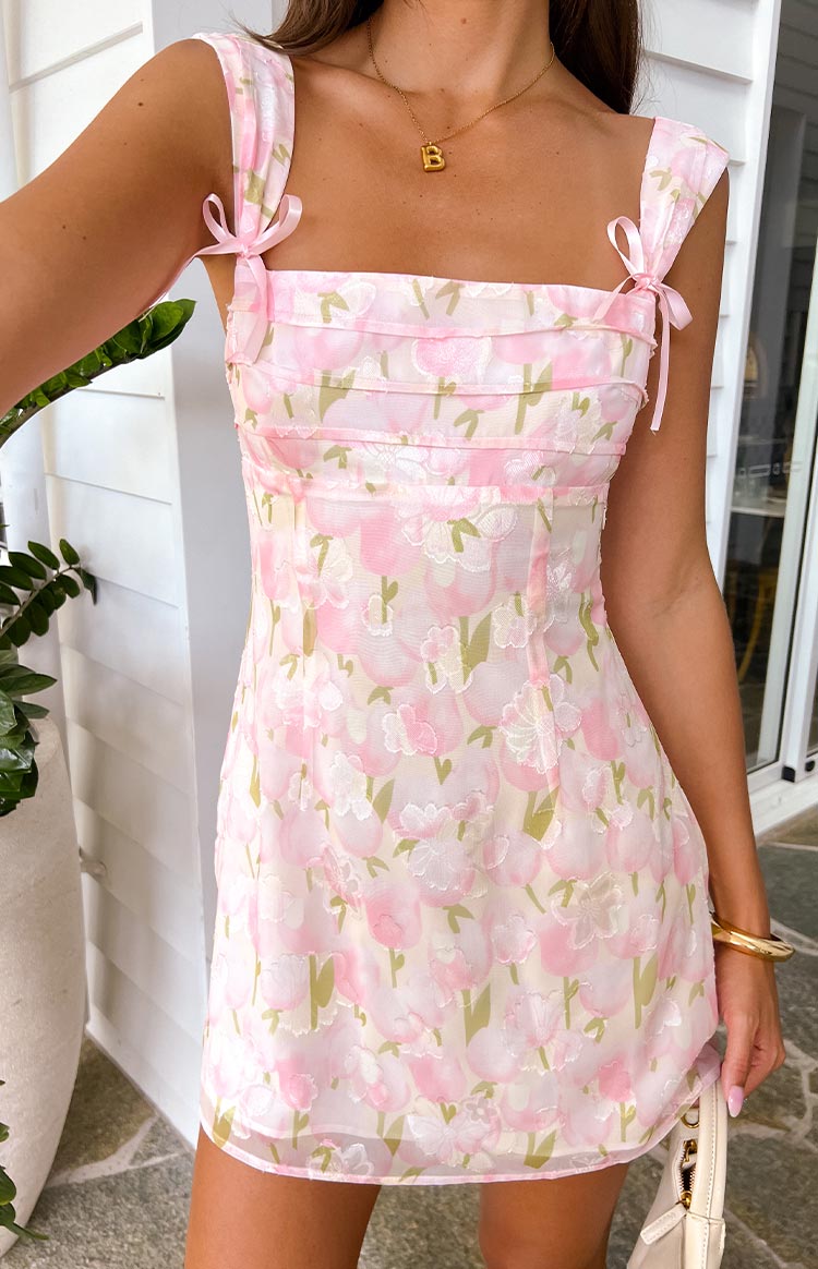 Close-up of the pink floral mini dress showing the square neckline, tie-up shoulder straps, and ruched bodice