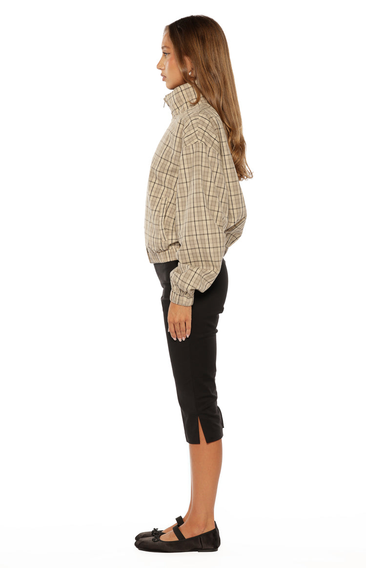 Side view of a beige plaid funnel neck jacket with a relaxed fit and elasticated cuffs
