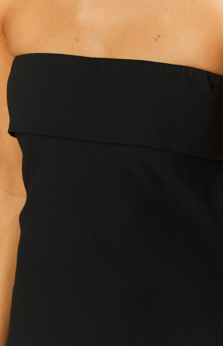 Close-up of the black strapless maxi dress showing the wide folded band detail at the neckline