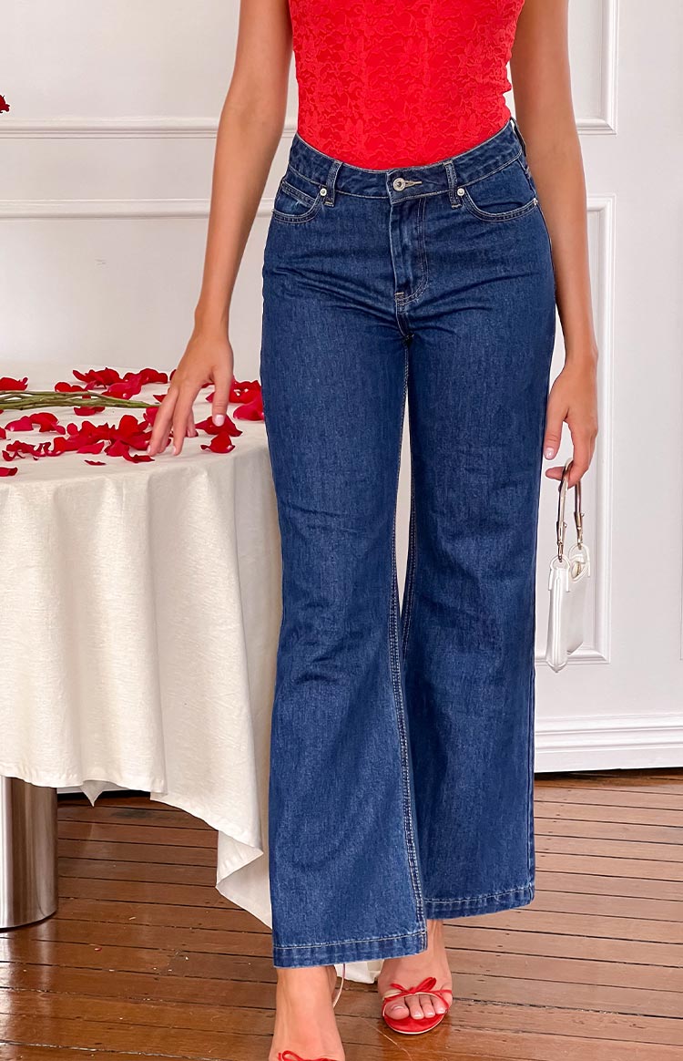 Front view of dark blue denim flare jeans featuring a high waist, button closure, and classic front pockets