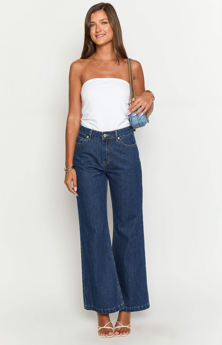 Full length front view of dark blue denim flare jeans with a high waist and wide leg