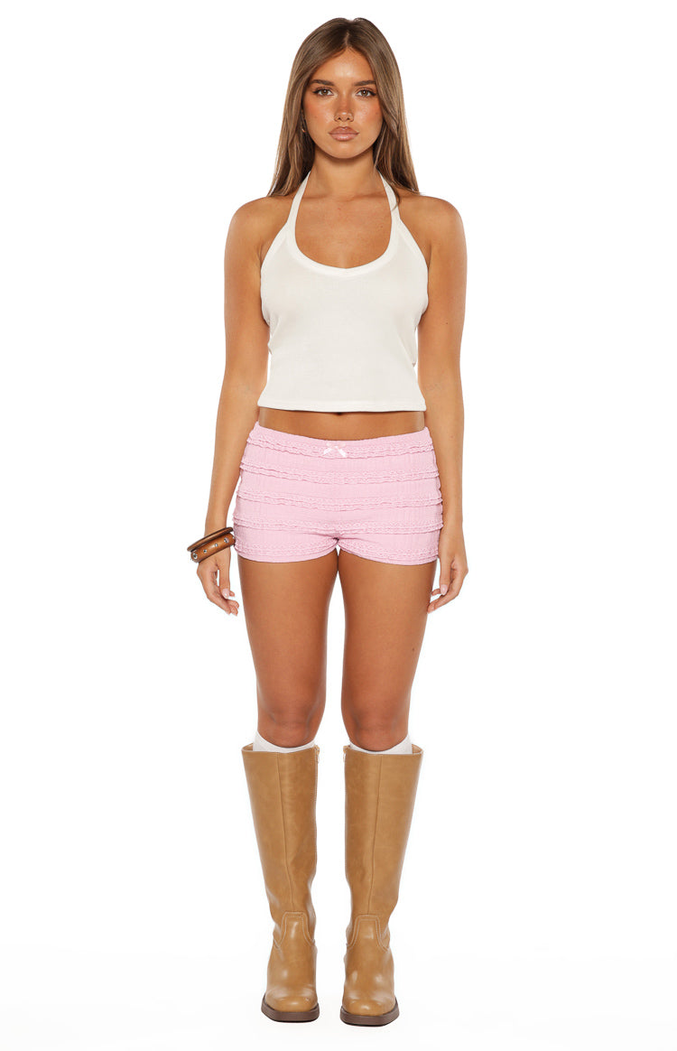 Front view of pink micro shorts with tiered lace ruffles and a small white bow detail