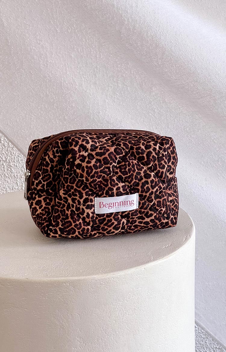 Leopard print makeup bag with white logo patch and silver zipper