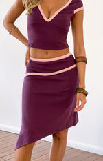 Grape asymmetric skirt with a curved pink contrast bind detail and an angled hemline