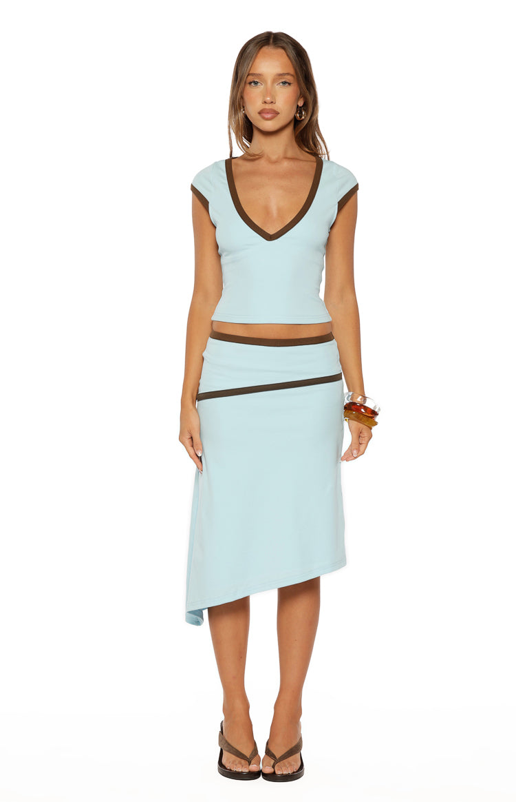 Light blue midi skirt with brown contrast binding on the waist and a diagonal stripe, featuring an asymmetric hem