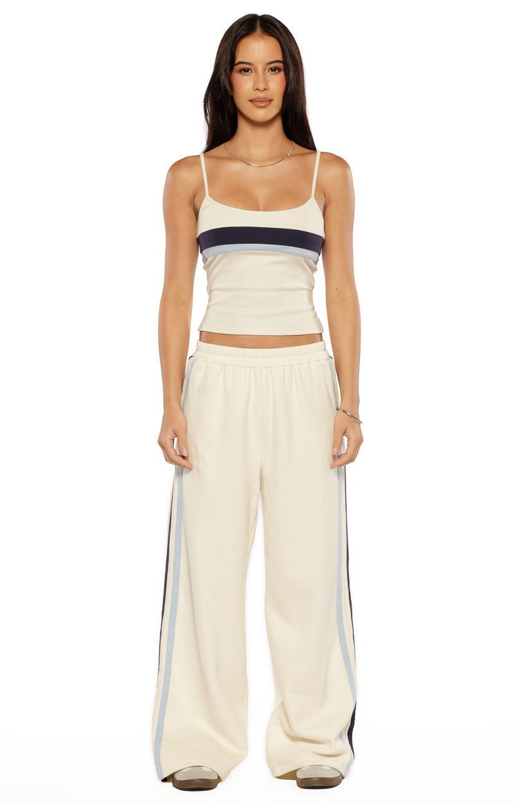Front view of off-white wide-leg pants with elasticated waist and navy and light blue side stripes