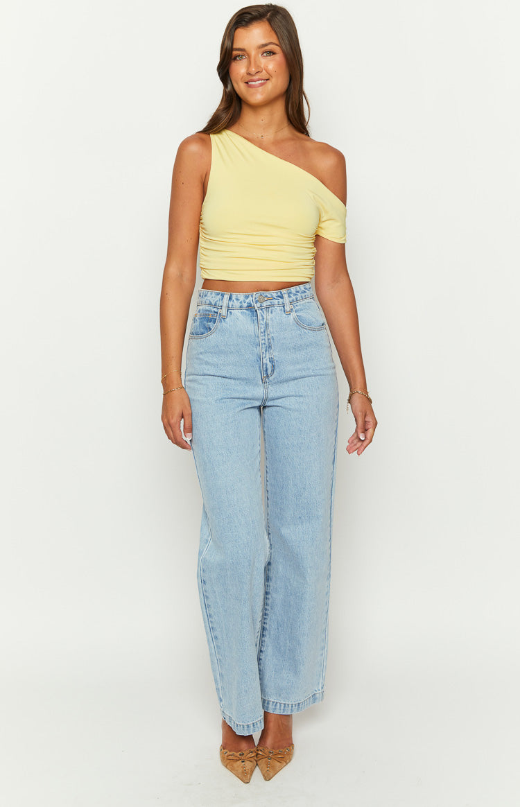 Front view of a yellow one-shoulder draped crop top with a short sleeve and ruched side detail