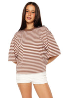 Woman in a brown and pink striped oversized cropped tee with white shorts a sweet and casual look for Spring