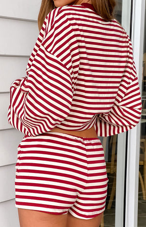 The back view of fitted short shorts featuring horizontal red and white stripes and an elastic waistband.