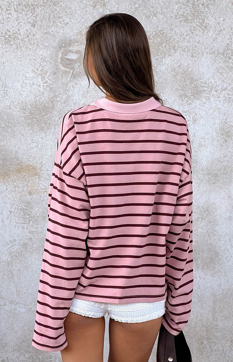 The back view of our oversized pink knit polo sweater with dark maroon horizontal stripes and a pink collar showcasing the dropped shoulder and casual fit.