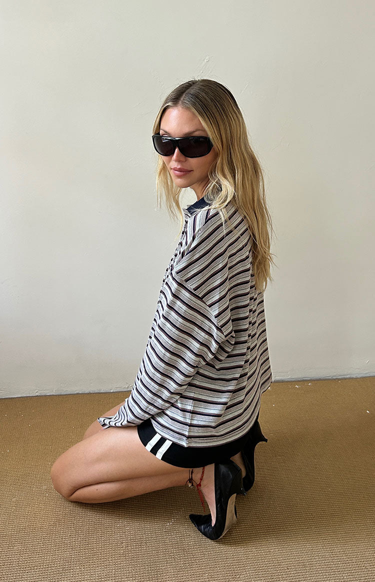 Side view of an oversized black and white striped long sleeve jersey with a dark collar