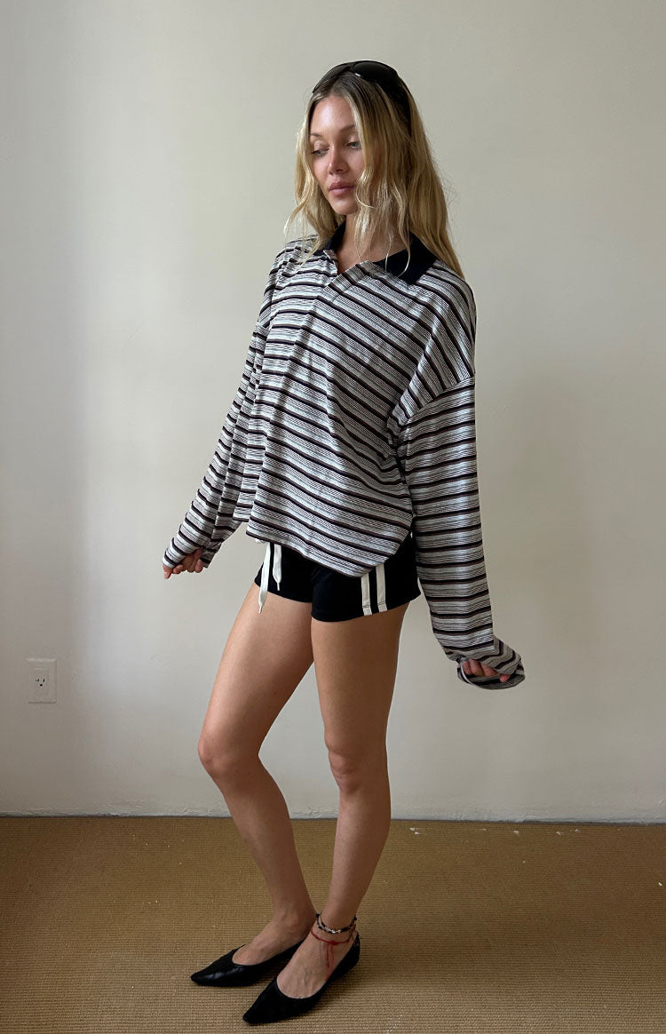 Side view of the black and white striped jersey showing its relaxed, oversized fit and long sleeves