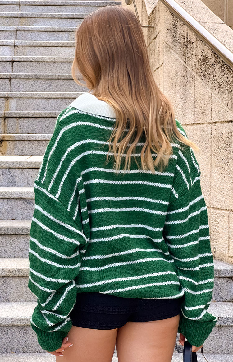 Rear view of an oversized forest green jersey with white horizontal stripes and a white collar