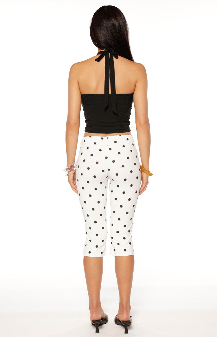 Rear view of the cream polka dot capri pants, showing the fitted style and mid-calf length