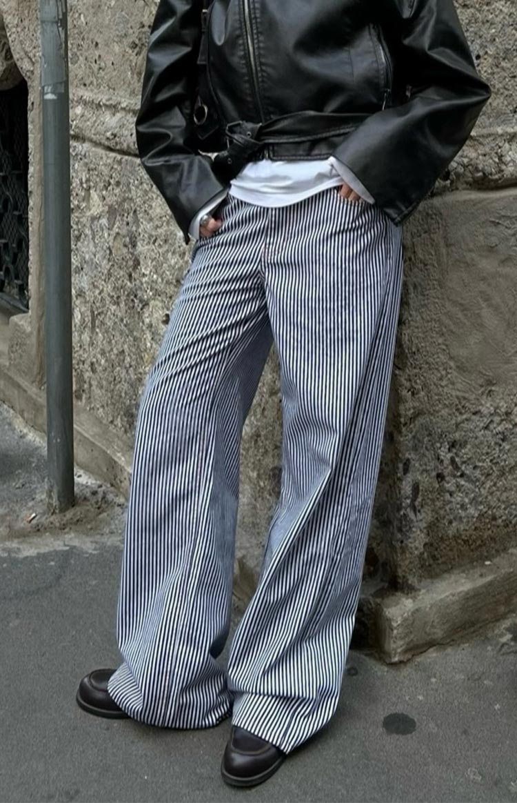 Full length view of wide-leg navy and white vertical stripe jeans with a relaxed drape