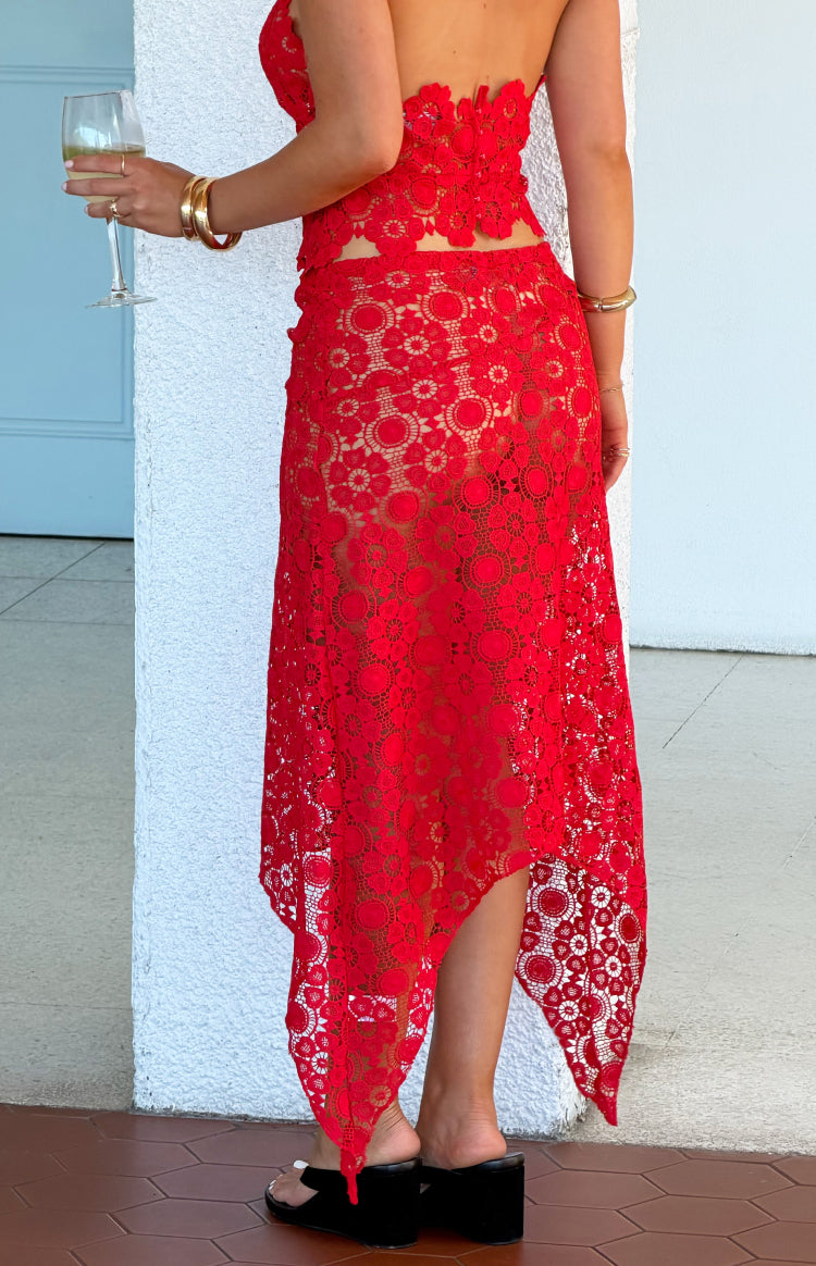 Side view of a red crochet midi skirt with an asymmetrical pointed hemline and sheer floral pattern