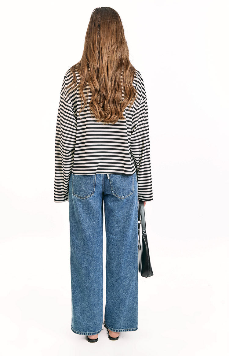 Rear view of a black and white striped long sleeve top with a relaxed fit and cropped hem