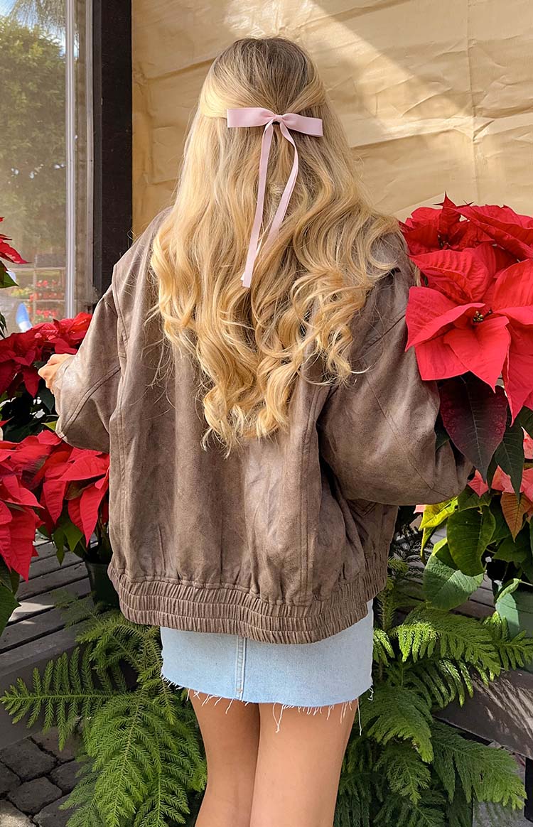 Rear view of a chocolate brown bomber jacket with an elasticated hem and textured fabric