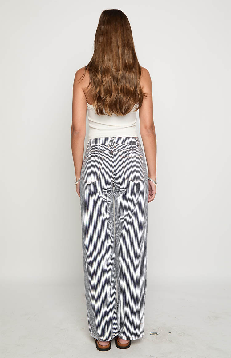 Rear view of navy and white striped wide-leg jeans with back pockets and orange contrast stitching