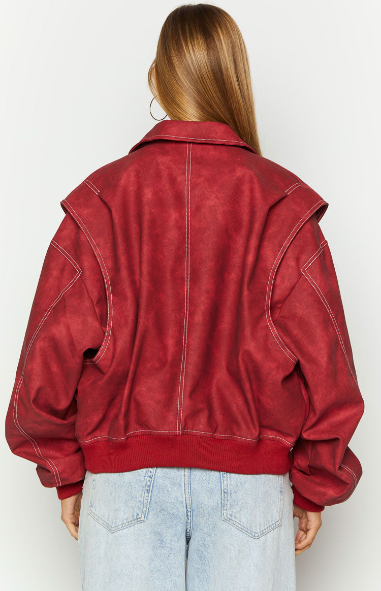 Rear view of a crimson bomber jacket with white contrast stitching, wide collar, layered shoulder design, and ribbed hem