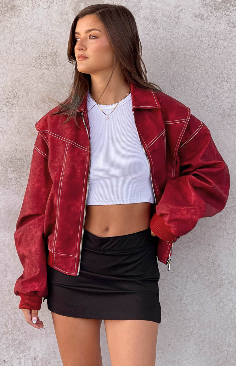 Crimson red distressed bomber jacket with white contrast stitching, open front, and ribbed cuffs