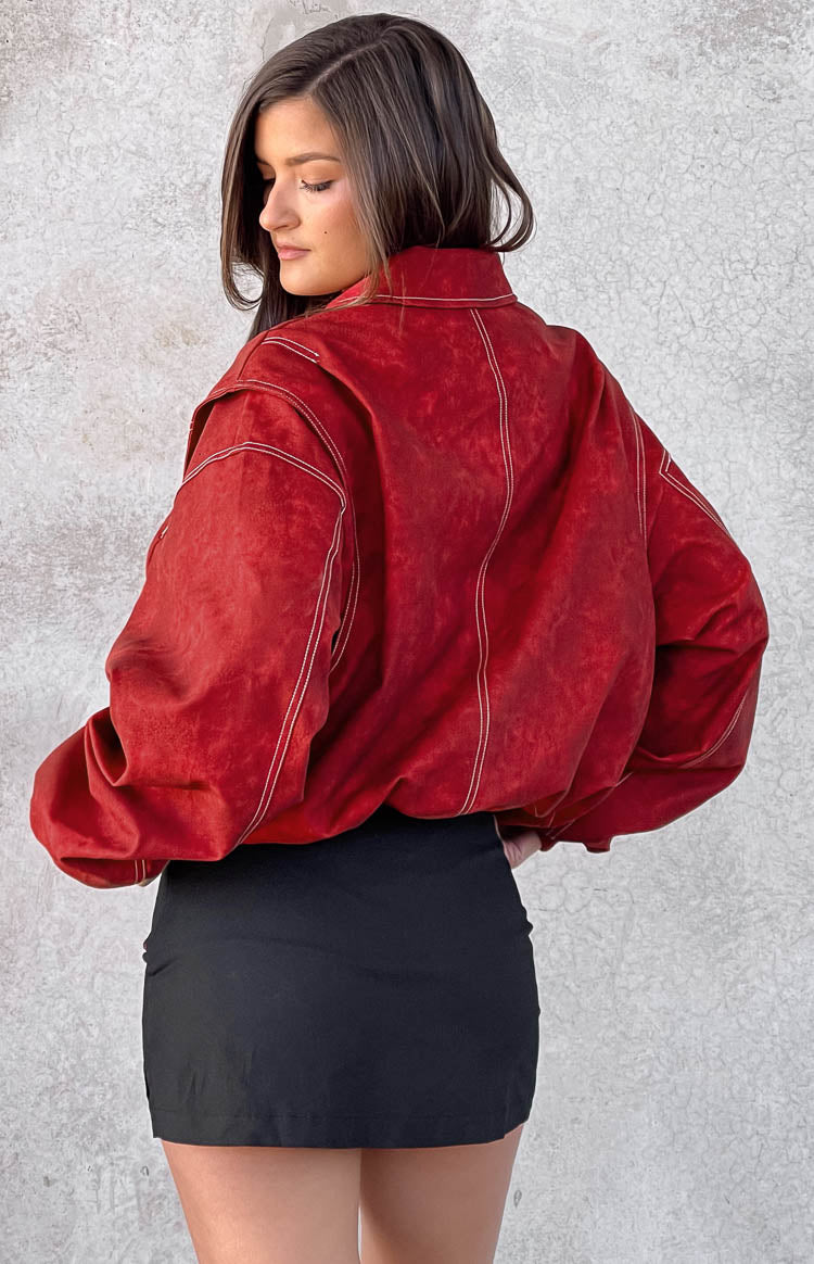 Rear view of a crimson bomber jacket with white contrast stitching and dropped shoulders