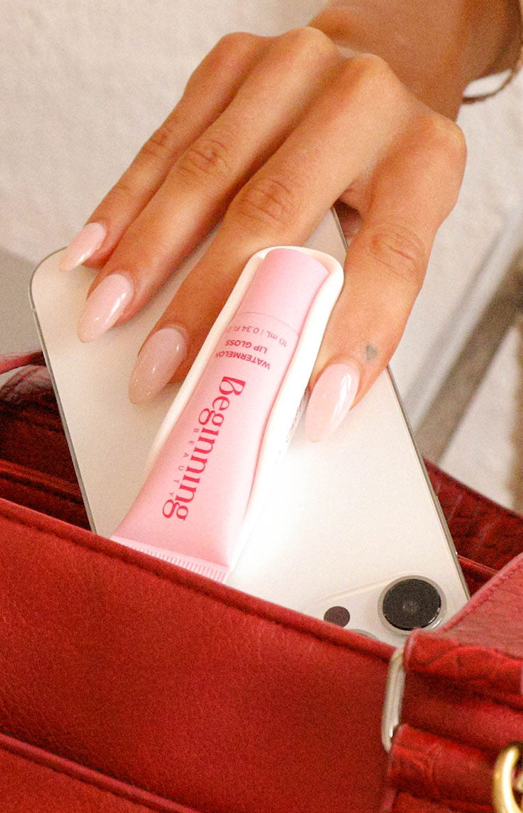 Close-up of the white phone holder with a pink lip gloss tube attached to the back of a phone