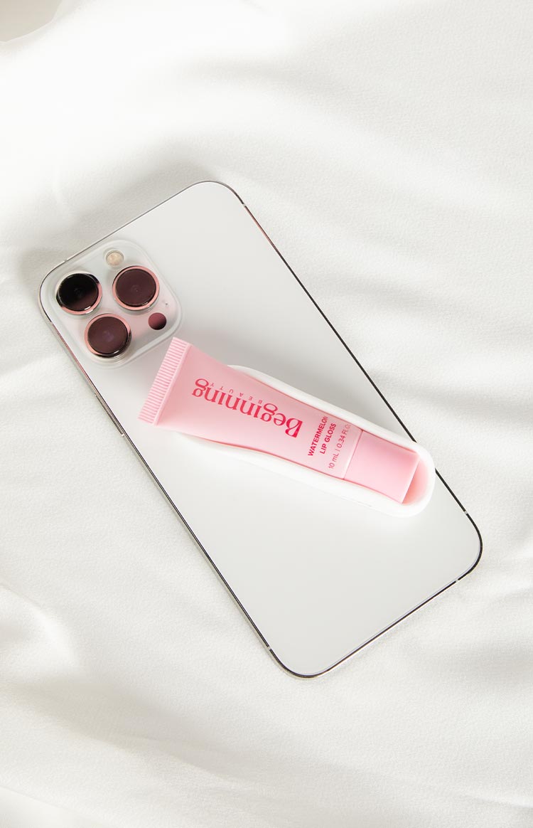 White phone holder with a curved, open top, designed to hold a pink lip gloss tube on a phone