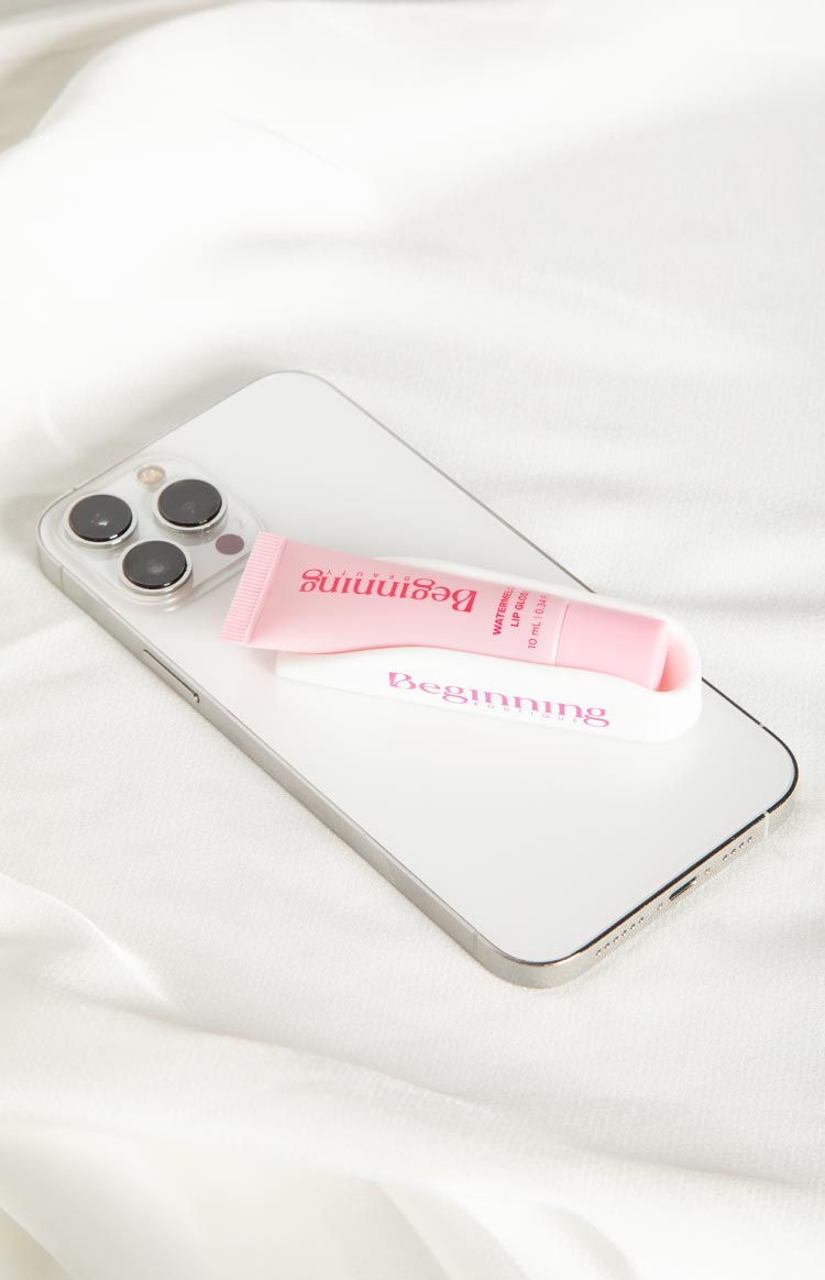 White phone holder with pink lip gloss tube in its cradle, attached to a silver phone