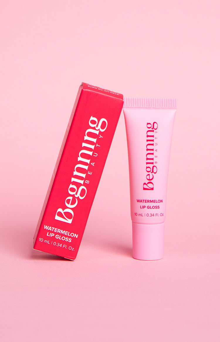 Red rectangular box and light pink squeeze tube of lip gloss, with ribbed cap detail on the tube