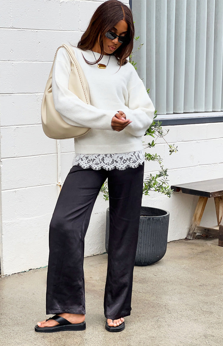 Cream long sleeve knit with a white scalloped lace trim peeking from the hem