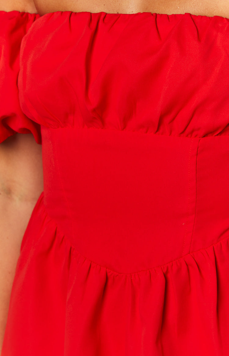 Close-up of the red mini dress showing the gathered off-shoulder neckline, fitted waistband, and gathered skirt