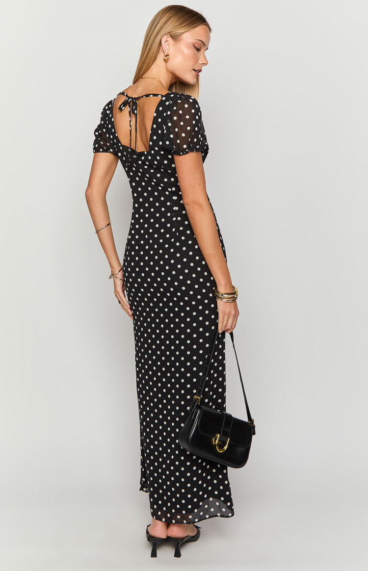 Rear view of a black polka dot maxi dress with a square back neckline, tie closure, and short puff sleeves