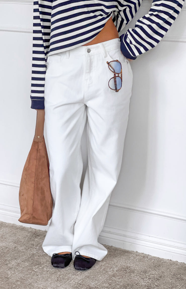Close-up of the front of white denim slouchy jeans with a button fly and relaxed leg