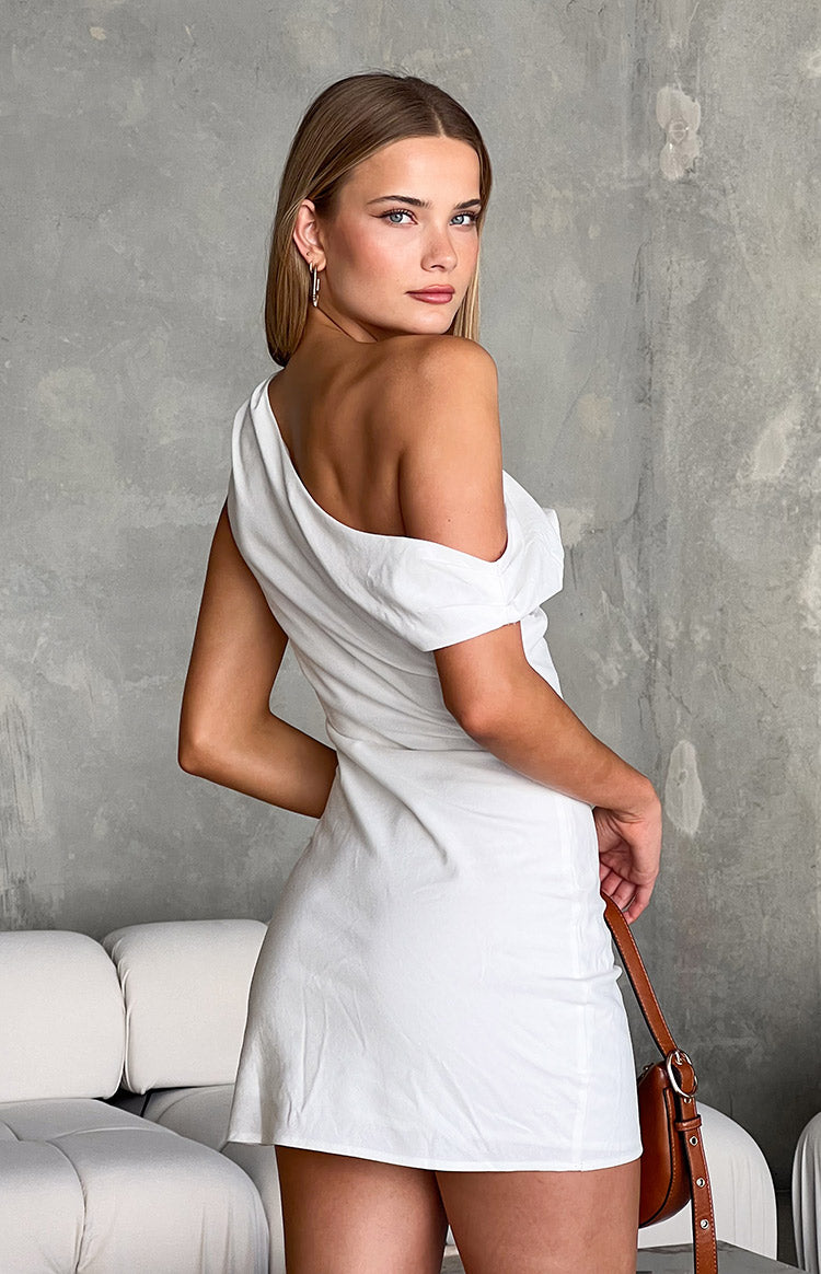 Rear-side view of a white one-shoulder mini dress with a draped neckline and fitted silhouette