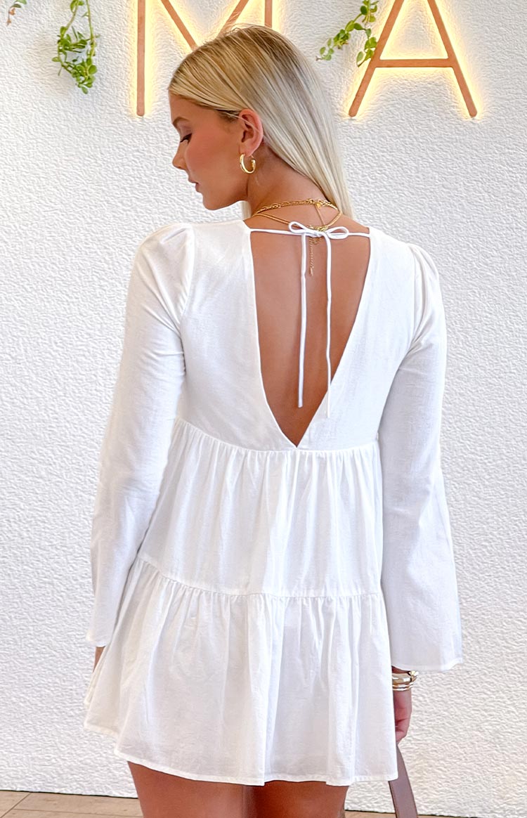 Beginning Boutique Lucky Heart White Long Sleeve Mini Dress white long sleeve mini dress with a deep V-back, tie closure, and tiered skirt
