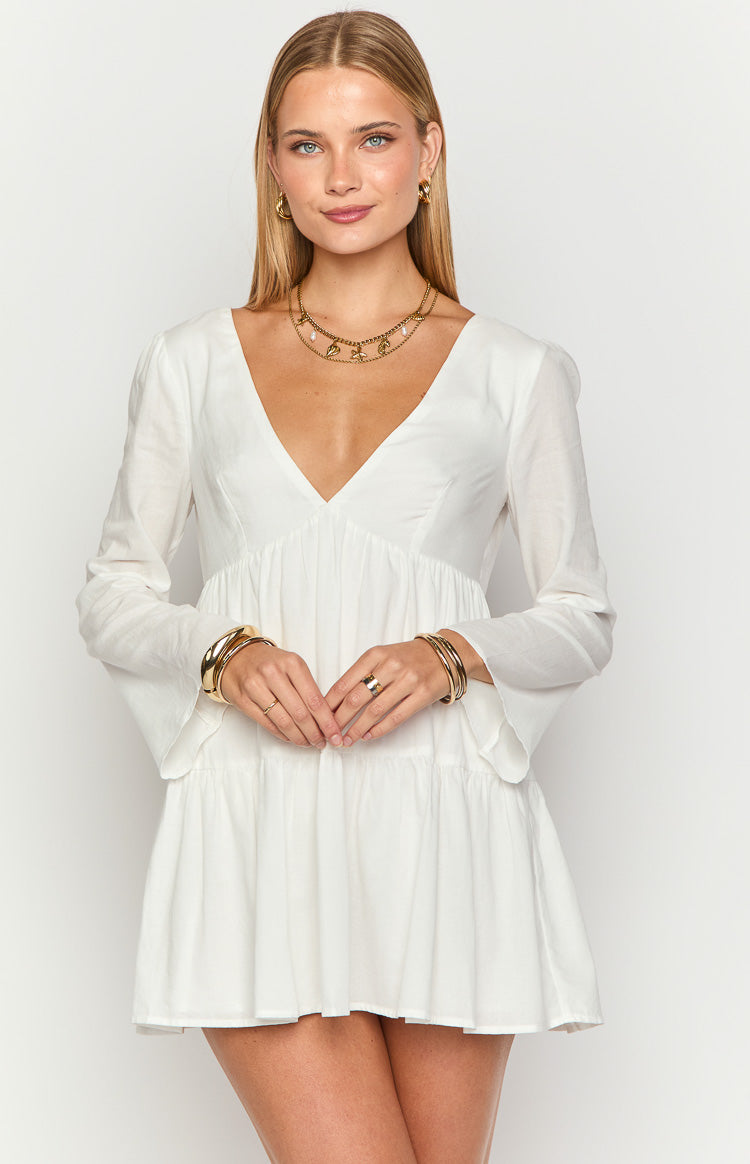White long sleeve mini dress with a deep V-neckline, empire waist, and flared cuffs