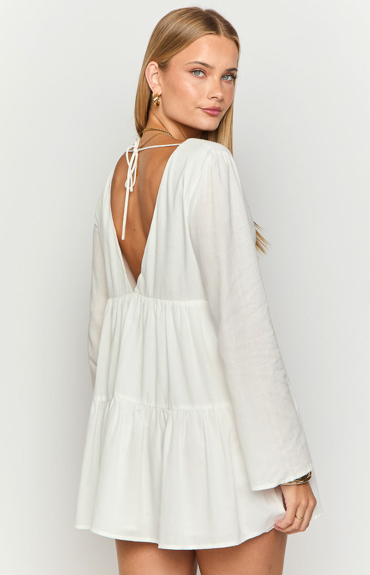 Deep V-back with self-tie straps on a white long sleeve mini dress, showing the tiered skirt