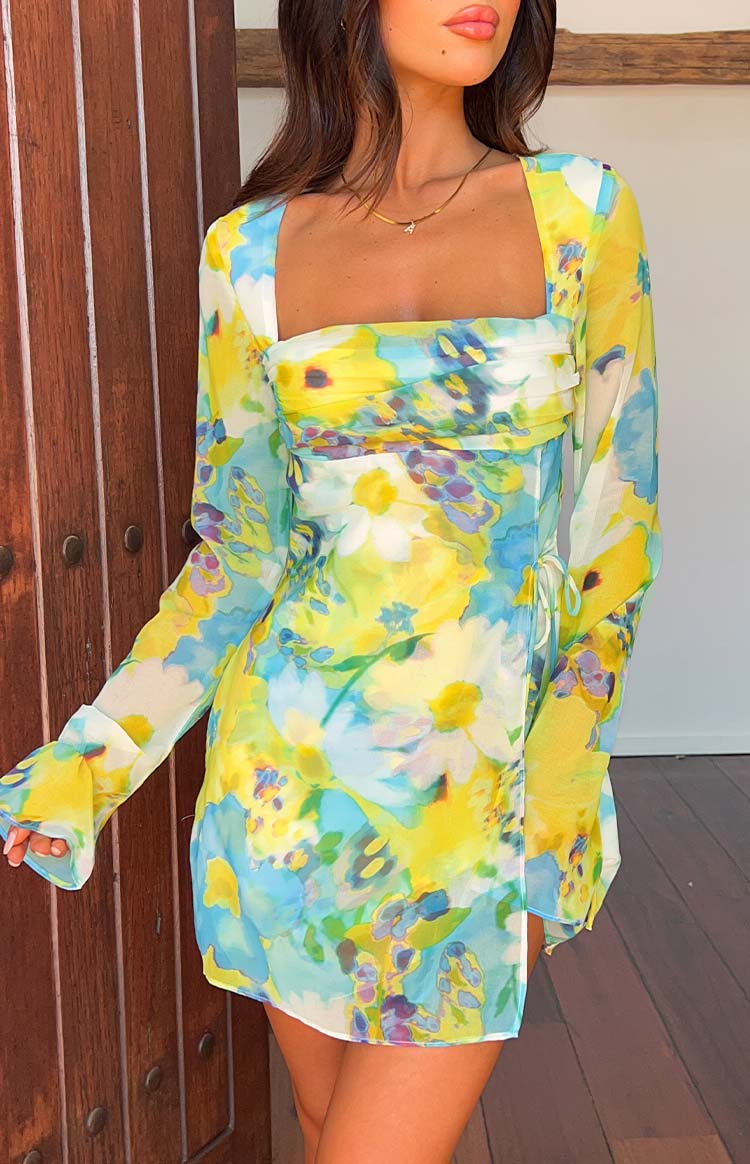 Front view of the yellow and blue floral mini dress with a square neckline, ruched bust, and side tie wrap skirt