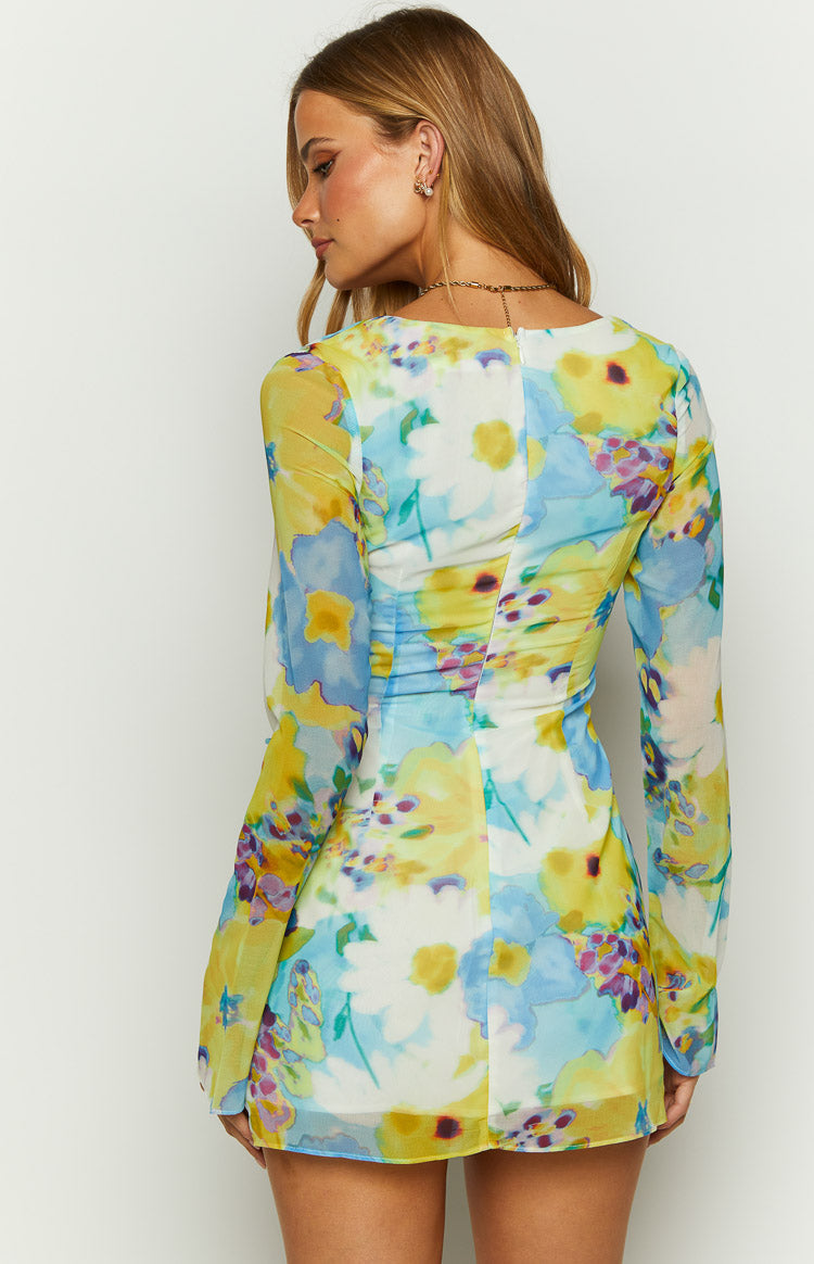 Rear view of a blue floral long sleeve mini dress with a back zipper and ruched sides