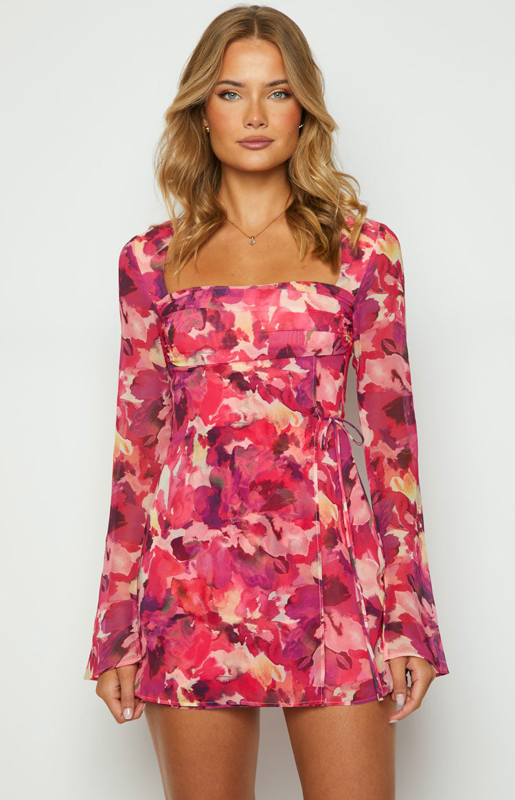 Front view of a pink floral print mini dress with a square neckline, long sleeves, and a tie waist detail