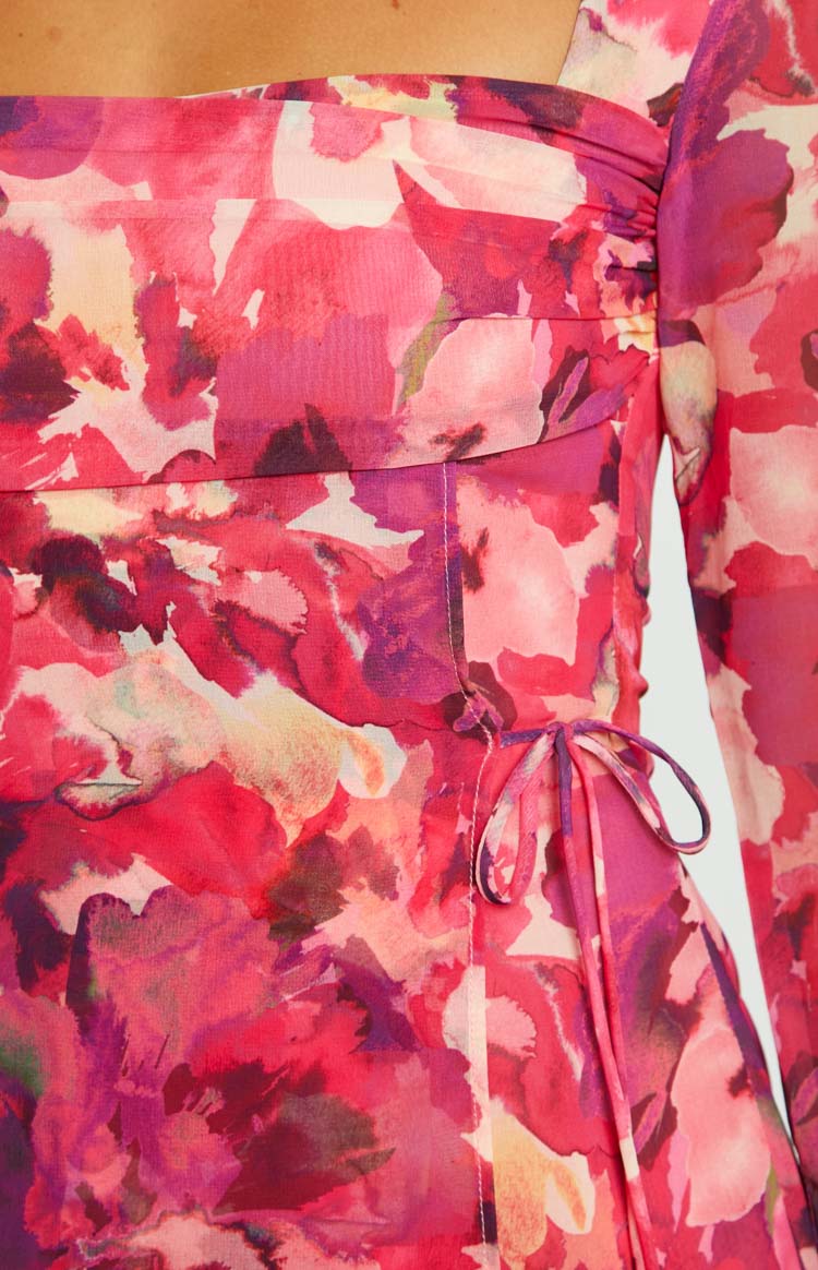 Detail shot of the ruched bodice and side tie on the pink floral print dress