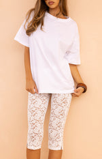 Close up of white lace cropped leggings with a scalloped hem perfect for a trendy Festival or Summer look