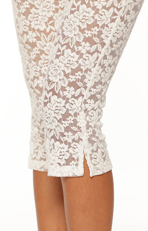 Close-up of the white floral lace capri pants showing the side slit and ruched detail at the hem