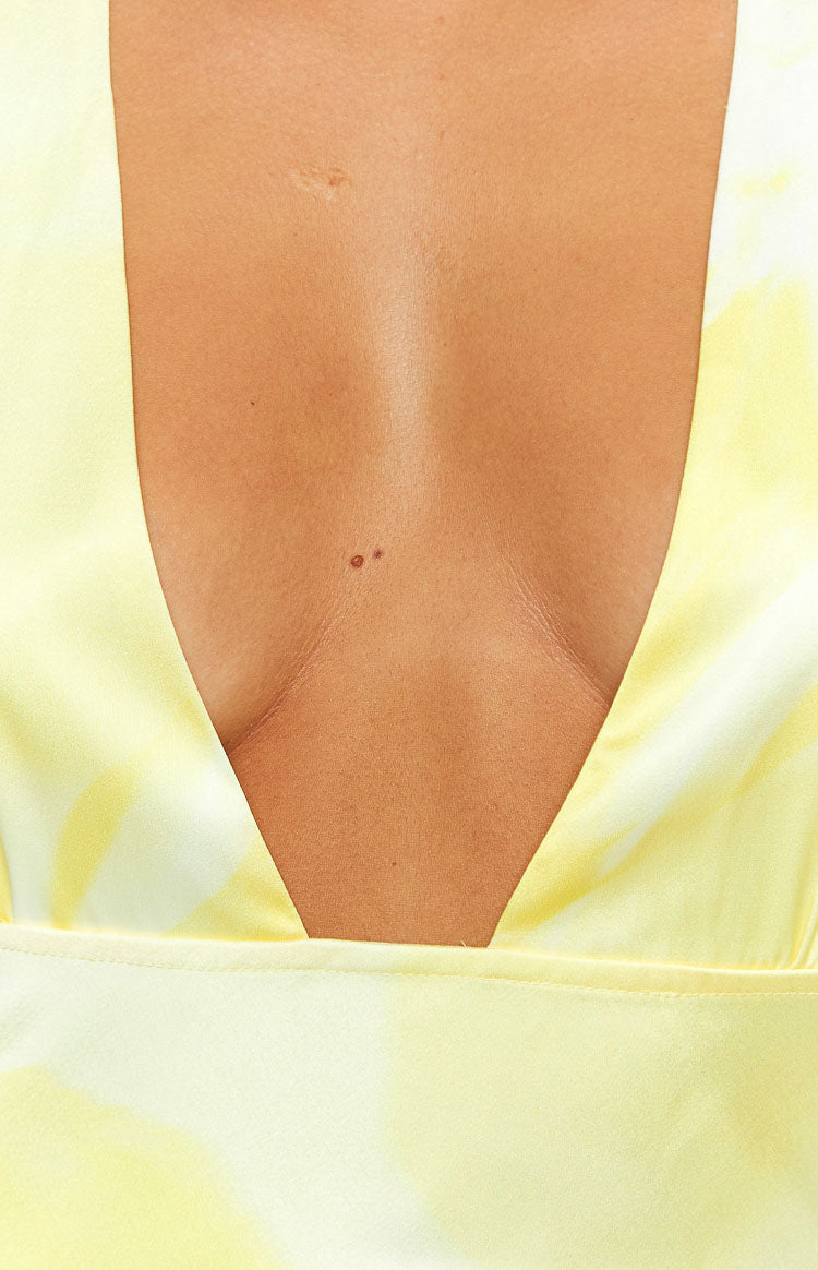 Close-up of the deep V-neckline on a yellow and white patterned dress