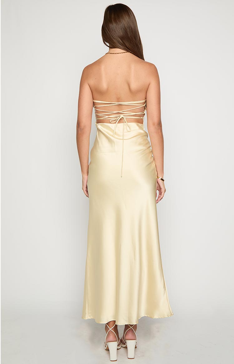 Rear view of a yellow satin maxi dress with a strappy lace-up back and open cutout detail