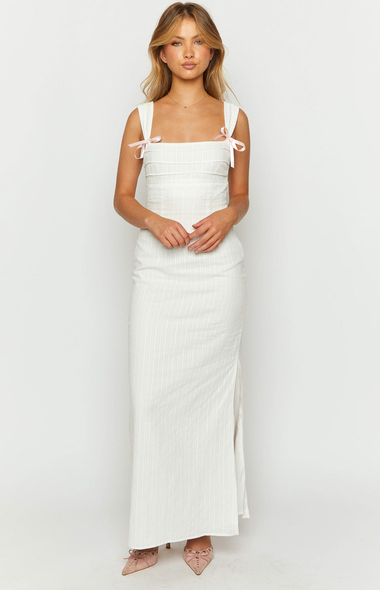 Front view of a white square neck maxi dress with pink bow tie shoulder straps and a ruched bodice