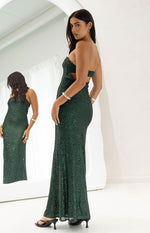Side view of an emerald green sequin maxi dress with a strapless neckline and side cutout