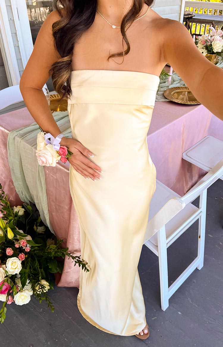 Close-up of the strapless neckline and fitted bodice of a pale yellow maxi dress
